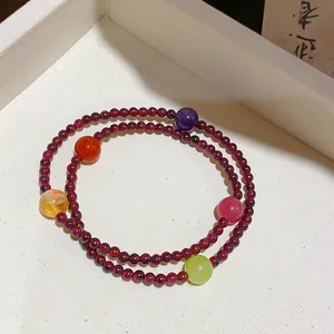 Dettaglio di un braccialetto di granato con pietre colorate su un vassoio bianco