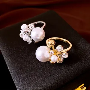 Elegant luxury flower open ring featuring white pearls and sparkling zircons on a box