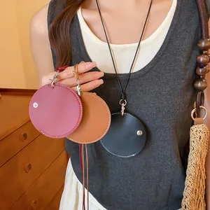 Gros plan d'un collier pendentif en cuir circulaire et d'un clip pour lunettes de plusieurs couleurs.