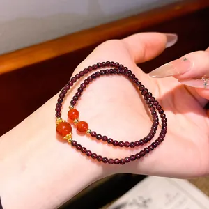 Dettaglio del braccialetto di perle di granato in stile cinese con eleganti tocchi dorati