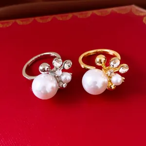 Detailansicht von eleganten Perlenblumenringen mit Zirkoniasteinen in Gold und Silber