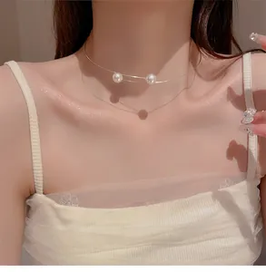 Collier choker minimaliste en fil d'or avec deux perles élégantes sur un mannequin