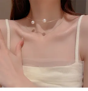 Détail en gros plan d'un collier ras-de-cou en fil avec des perles blanches élégantes sur un modèle