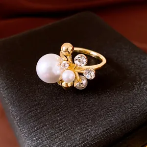 Makrodetail eines eleganten goldenen Rings mit Perlen und Zirkon-Blumendesign