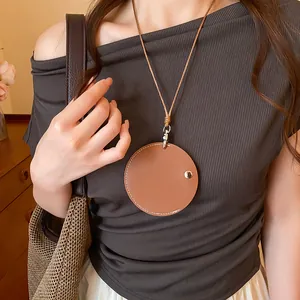 Vue détaillée d'un collier pendentif porte-lunettes circulaire en cuir marron.