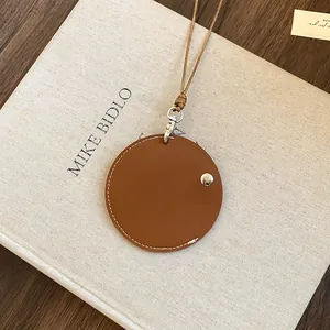 Collier porte-lunettes rond en cuir marron avec coutures blanches et cordon beige.