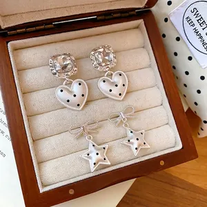 Elegante zilveren naald oorbellen met hart- en sterhangers met stippen in houten doosje