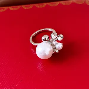 Nahaufnahme eines eleganten Blumenrings mit Perlen und Kristallen auf rotem Grund