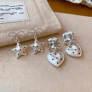 Elegante zilveren oorbellen met ster- en hartvormige hangers en polka dot-ontwerpen