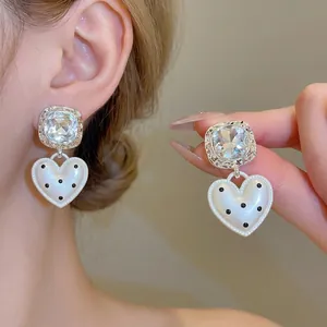 Zilveren oorknopjes met hartvormige hanger met stippen en sprankelende diamanten