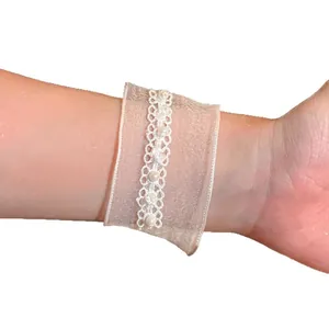 Elegante bracciale in nastro di organza bianco con perle e pizzo delicato indossato al polso