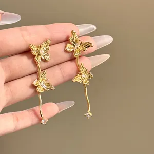 Gros plan de boucles d'oreilles papillon dorées élégantes avec des détails en strass brillants.