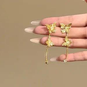 Détail de boucles d'oreilles papillon dorées vintage avec zircons brillants