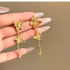 Gros plan d'élégantes boucles d'oreilles papillon dorées avec des détails en strass