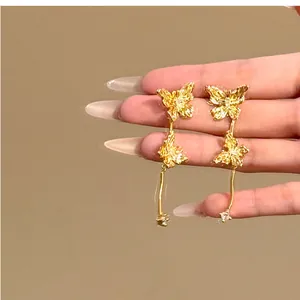 Vue détaillée d'élégantes boucles d'oreilles papillon dorées avec accents de diamants