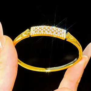 Detailed macro shot of an 18K gold plated bangle featuring a sparkling zirconia pavé plaque.