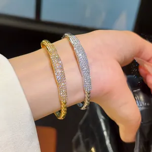 Close-up of elegant 18K gold and silver plated zircon paved bangle bracelets