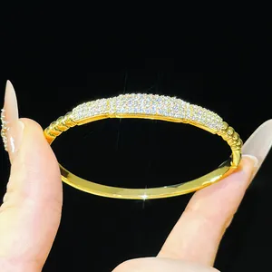 Detailed view of an 18K gold-plated bangle bracelet with pave-set shimmering zircons