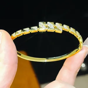 Macro view of a luxury 18K gold plated buckle bangle featuring intricate zircon stone details