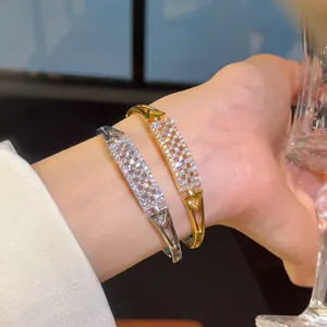 Close-up of 18K gold plated zircon bangles with sparkling rectangular grid design