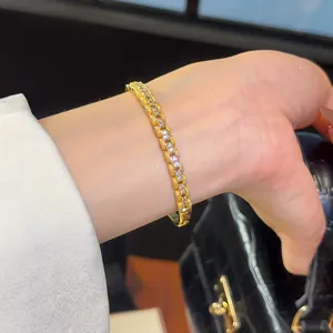A detailed view of a luxury 18K gold-plated bangle featuring sparkling zirconia stones