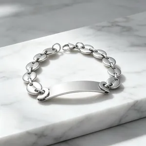 Detailopname van zilveren titanium stalen armband met varkensneus-schakels en graveerplaat