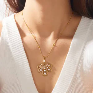 Gros plan d'un élégant collier feuille plaqué or avec émail blanc porté par un mannequin.