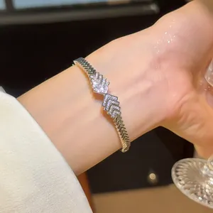 Detail of a sparkling zircon geometric chevron bracelet with 18K gold plating on wrist
