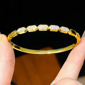 Macro detail of 18K gold plated bangle featuring hexagonal zircon encrusted links