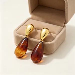 Detaillierte Nahaufnahme von Vintage Bernstein Harz Ohrringen in goldenem Edelstahl