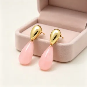 Detailansicht eleganter Vintage-Ohrringe mit rosa Harz und goldenem Metallfinish.