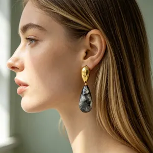 Elegante Seitenansicht eines Models mit klassischen Tropfenohrringen aus Harz und Gold