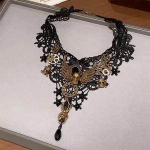 Detailopname van een gotische zwarte kanten choker met steampunk schedel en spin hangers.