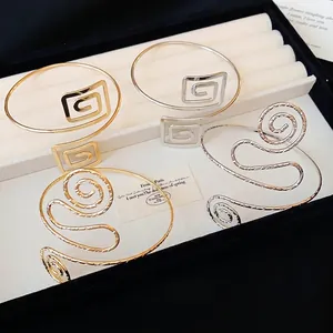 Minimalistische Armreifen aus Gold- und Silbermetall mit geometrischem Spiraldesign
