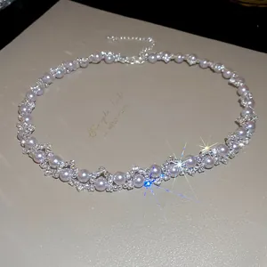 Dettaglio di una collana di perle in stile francese con brillanti accenti di strass.