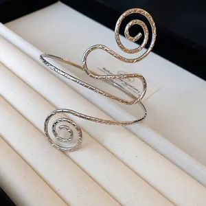 Close-up detail showing the unique textured spiral design of silver metal arm cuff bracelet
