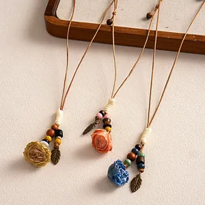 Colliers ethniques faits main avec fleurs en céramique, perles bois et pendentifs feuilles.