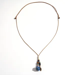 Long collier style ethnique avec fleur en céramique bleue et perles en bois sur cordon