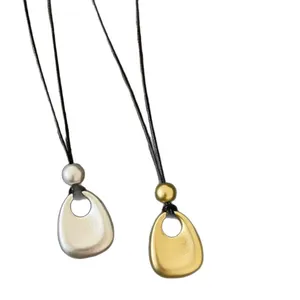 Colliers à pendentif en métal mat teintes dorée et argentée avec cordon noir.