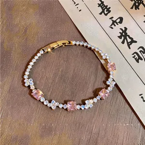Close-up of an elegant gold bracelet featuring sparkling pink square zirconia stones.