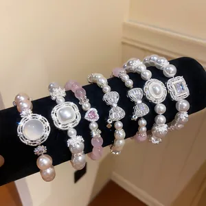 Detailansicht von Perlenarmbändern mit Katzenaugenstein und Zirkonia-Anhängern