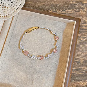 Detail showing pink square zircons and clear stones on a gold-toned tennis bracelet.