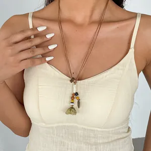 Vue détaillée d'un collier bohème avec perles en bois et pendentif fleur verte