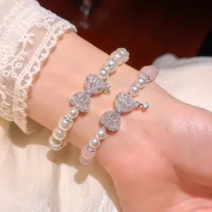 Elegante Nahaufnahme von Perlenarmbändern mit Zirkonia-Schleifen und rosa Katzenaugenstein