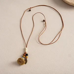 Vue détaillée du collier bohème avec pendentif fleur en céramique et perles de bois