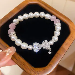 Nahaufnahme von elegantem Perlen- und Natursteinarmband mit funkelnder Zirkonia-Schleife