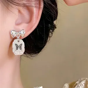 Pendientes de lazo plateados con colgante de mariposa para mujer de estilo coreano.