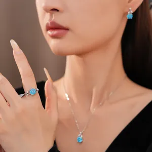 Detailed shot of elegant blue zircon flower necklace, ring and earrings on model.