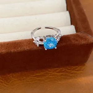 Detailed view of an elegant silver ring with a blue cubic zirconia and leaf-shaped accents