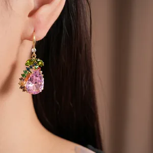 Gros plan d'une boucle d'oreille vintage avec zircon rose en poire et détails colorés